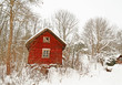 Very old red wooden house in a snowy forest