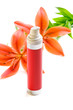 Bottle of cream/lotion with lily flowers, closeup shot, on white Bottle of cream/lotion with lily flowers, closeup shot, on white