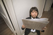 Young boy reading newspaper comically