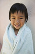 Young girl smiling wrapped up in towel