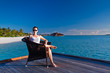 Young woman relaxing on deck overlooking lagoon