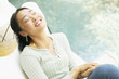 Woman sitting with eyes closed outdoors