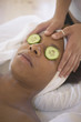 Woman with cucumbers over eyes