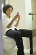 Businesswoman on toilet with cell phone