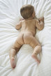 Naked backside of baby on bed