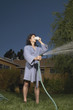 Man in robe watering grass