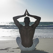 Man doing yoga at beach
