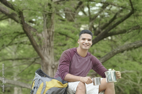 Photo: Young man camping in a forest Young man camping in a forest