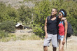 African American couple with backpacks hugging outdoors