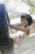 African American woman sitting in tire swing