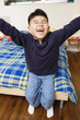 Boy sitting on bed and laughing