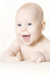 Happy active baby lying on stomach over blanket. Abstract backgr