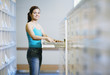 Woman standing by library file drawer