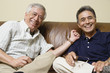 Portrait of elderly men sitting on the couch laughing
