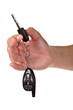 Hand holding car keys and a remote control