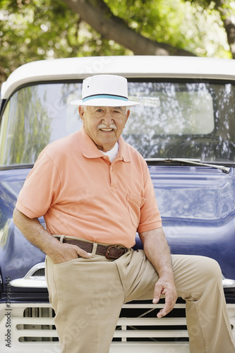 Photo: Portrait of elderly man leaning on old pickup truck Portrait of elderly man leaning on old pickup truck