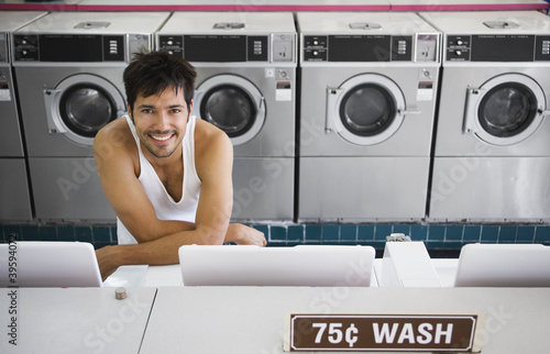 Photo: Portrait of man in tank top at laundromat Portrait of man in tank top at laundromat