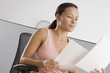 Businesswoman reading papers in office