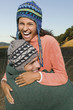 Couple in stocking caps hugging and laughing
