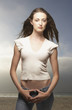 Portrait of woman standing with thumbs hooked in jeans