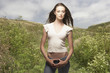 Portrait of woman standing with thumbs hooked in jeans