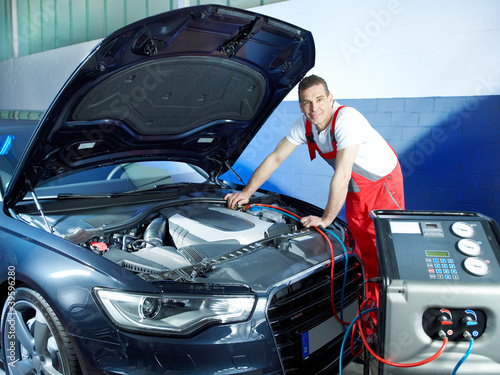 Photo: Motor mechanic working on engine bay with air handling unit Motor mechanic working on engine bay with air handling unit
