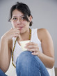 Photo: Young woman eating pudding with her fingers Young woman eating pudding with her fingers
