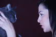 Young woman talking to her cat