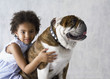 Portrait of young girl hugging bulldog