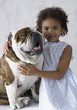 Portrait of young girl hugging bulldog