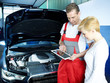 Photo: Motor mechanic shows female customer car details on touchpad Motor mechanic shows female customer car details on touchpad