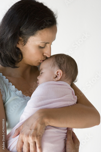 Photo: Mother kissing her sleeping baby Mother kissing her sleeping baby