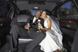 Newlyweds drinking champagne in their limo
