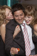 Man gambling as women fawn over him