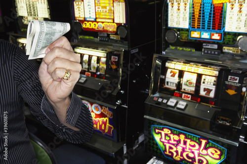 Photo: Young man holding his winnings at the casino Young man holding his winnings at the casino