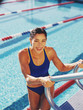 Young woman climbing out of a swimming pool