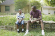 Father and son sitting on wall