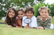 Photo: Kids playing with magnifying glass in park Kids playing with magnifying glass in park