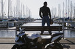 Young man standing on a pier bench