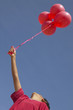Boy holding a bunch of balloons