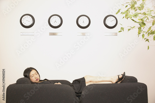 Photo: Businesswoman sleeping on couch in office Businesswoman sleeping on couch in office