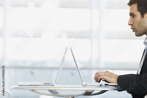 Photo: Profile of man typing on laptop Profile of man typing on laptop