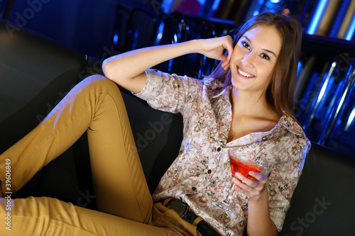 Photo: Attractive woman in night club with a drink Attractive woman in night club with a drink