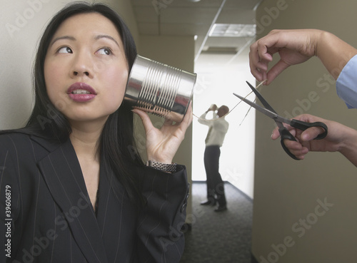 Photo: Business people talking with tin can on string Business people talking with tin can on string