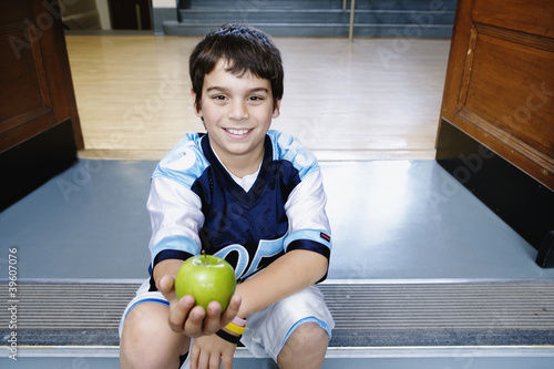 Photo: Portrait of boy on steps holding apple Portrait of boy on steps holding apple