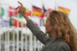 Woman hailing a taxi in front of international flags