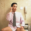 Businessman talking on phone while sitting on toilet