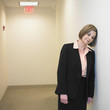 Businesswoman leaning head against wall