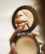 Young woman applying lip liner