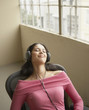 Businesswoman relaxing while listening to headphones